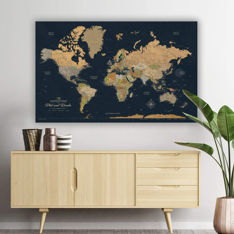 a large world map poster hanging on a wall above a wooden cabinet.