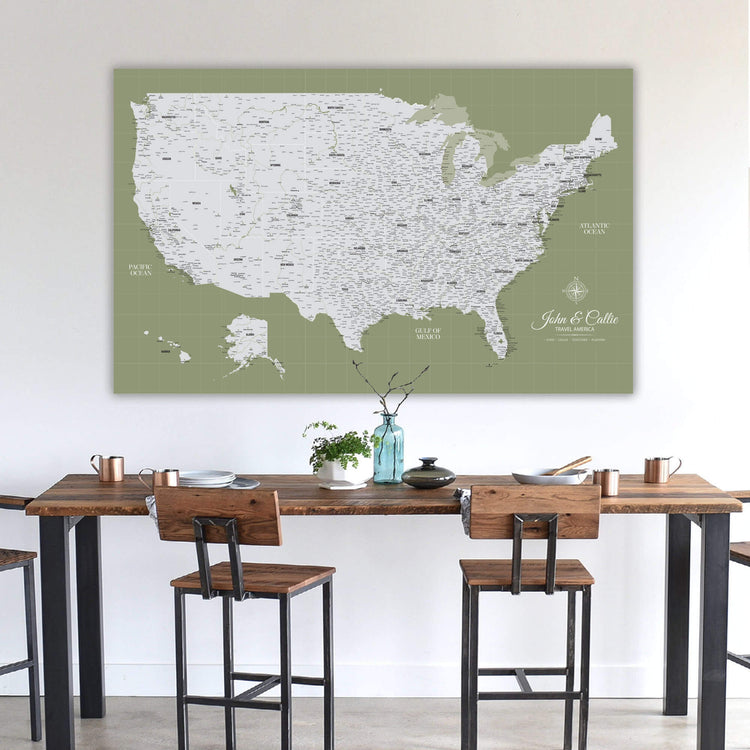 a large map of the United States displayed on a wall above a wooden dining table with chairs.