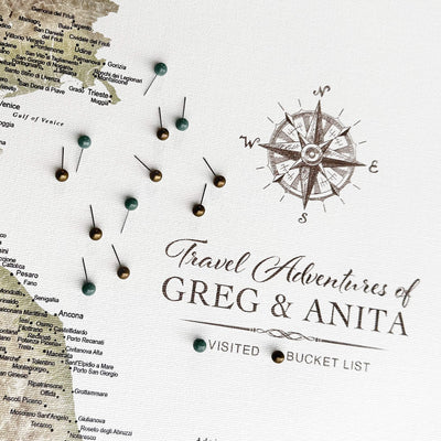 a map with pins and a compass rose, along with the text "Travel Adventures of Greg & Anita" and "VISITED BUCKET LIST" written on it.