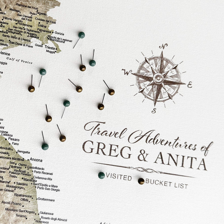 a map with pins and a compass rose, along with the text "Travel Adventures of Greg & Anita" and "VISITED BUCKET LIST" written on it.