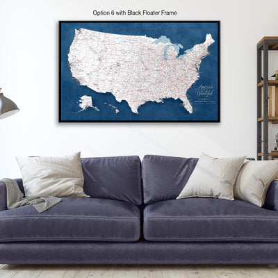 a large, detailed map of the United States displayed on a wall above a blue couch with pillows.