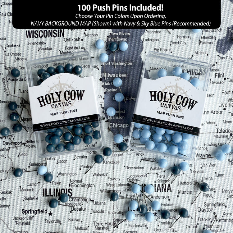 a collection of push pins in various shades of blue, arranged on a map background. The push pins are labeled "HOLY COW CANVAS PINS" and are displayed in two clear plastic containers. The map background includes the names of several cities, such as Milwaukee, Madison, and Chicago, as well as the names of states like Wisconsin and Illinois.