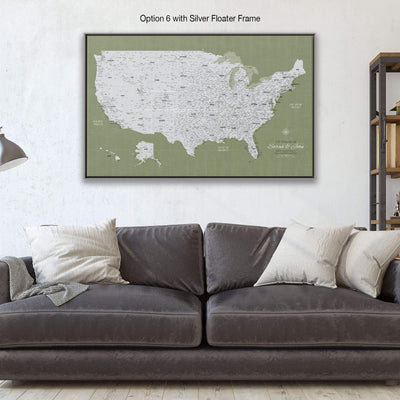 a large, detailed map of the United States displayed on a wall above a gray couch with white pillows.