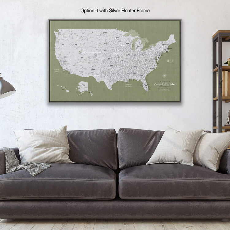 a large, detailed map of the United States displayed on a wall above a gray couch with white pillows.