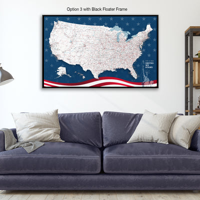 a large, detailed map of the United States with a black float frame, displayed on a wall above a blue couch with pillows.