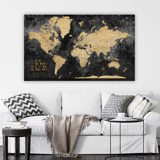 a living room with a white couch and a black and gold map on the wall
