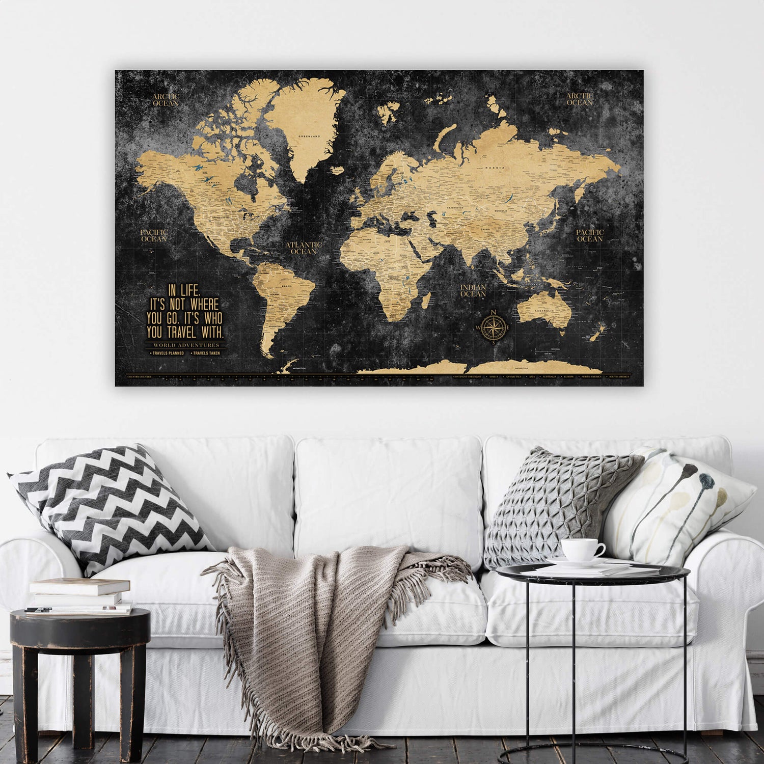 a living room with a white couch and a black and gold map on the wall