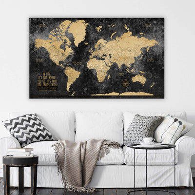 a living room with a white couch and a black and gold map on the wall