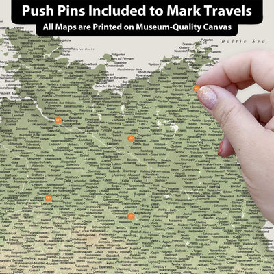 A hand is pinning a push pin to a map of the Baltic Sea region, which is printed on a museum-quality canvas.