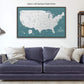 a large framed map of the United States with a dark blue couch and pillows in the foreground.