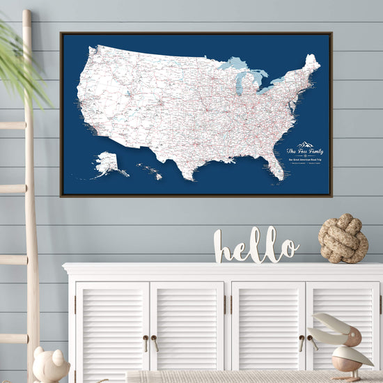 a large blue map of the United States hanging on a wall, with a white cabinet below it. There is also a small wooden figurine and a knotted rope decoration on the cabinet.