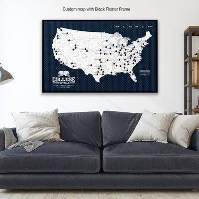 A large, custom map of the United States with various locations marked, displayed on a wall above a gray couch with white pillows.