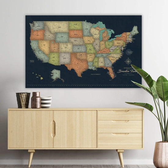 a large, detailed map of the United States hanging on a wall above a wooden cabinet.